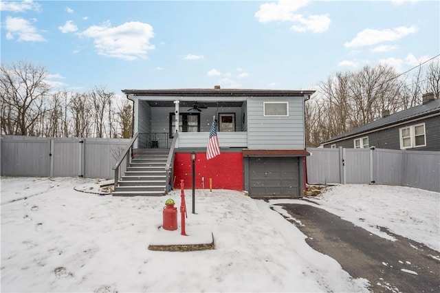 view of front of house featuring a gate, fence, and stairs