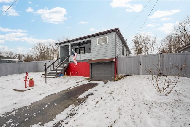 view of front of property with a garage, stairway, a fenced backyard, and a gate