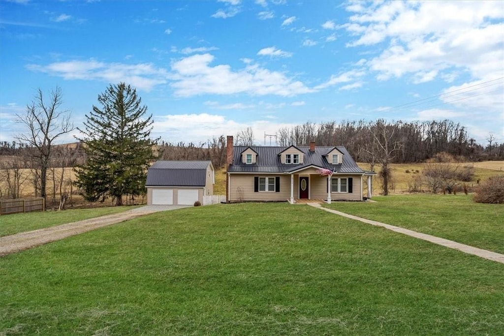 view of front of house with an outbuilding, metal roof, a garage, driveway, and a chimney