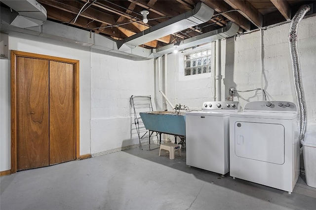 clothes washing area featuring laundry area, a sink, and washer and clothes dryer