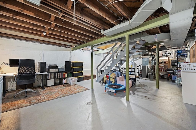 unfinished basement featuring concrete block wall, heating unit, stairs, and freestanding refrigerator