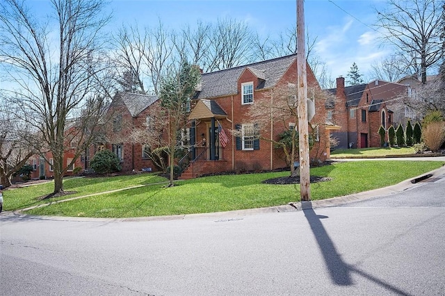 view of front of house with brick siding and a front lawn