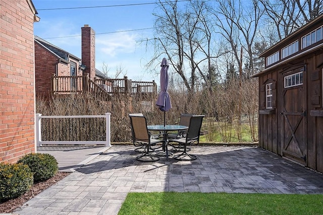 view of patio / terrace with a storage shed, outdoor dining space, and an outdoor structure