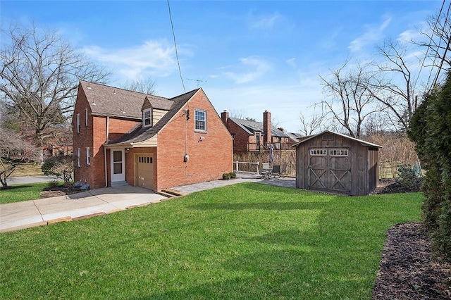 back of house featuring a garage, a lawn, concrete driveway, a storage unit, and brick siding