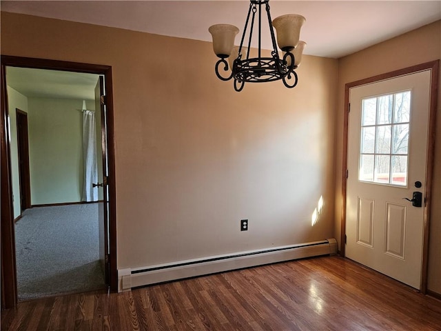 unfurnished dining area featuring a baseboard heating unit, an inviting chandelier, and wood finished floors