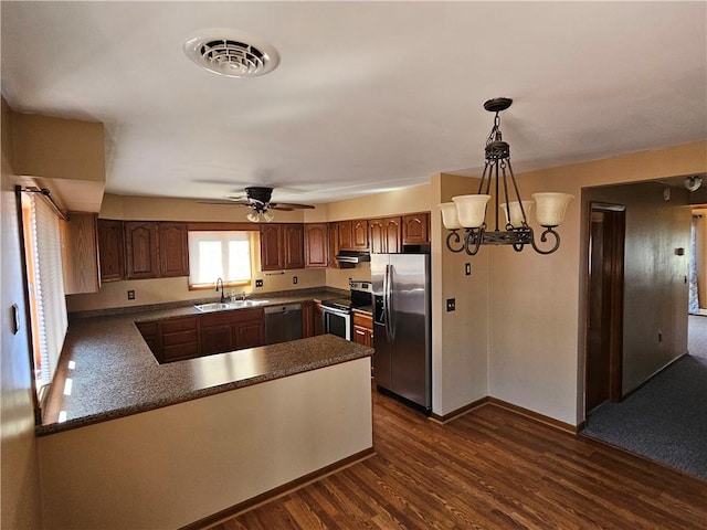 kitchen featuring visible vents, a sink, dark wood-type flooring, under cabinet range hood, and appliances with stainless steel finishes