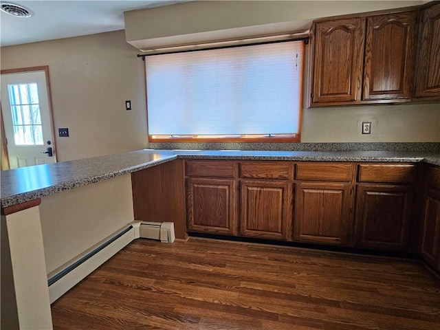 kitchen featuring visible vents, dark countertops, dark wood-style flooring, and a baseboard radiator