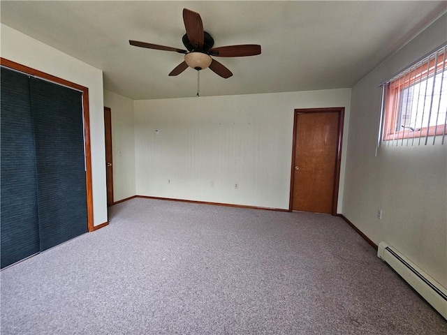 unfurnished bedroom featuring a ceiling fan, a baseboard heating unit, a closet, carpet, and baseboards