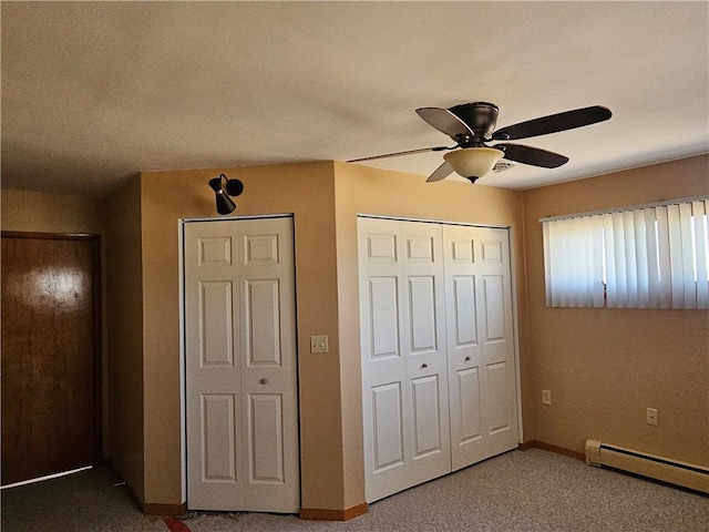 unfurnished bedroom with a baseboard heating unit, baseboards, carpet, and a ceiling fan