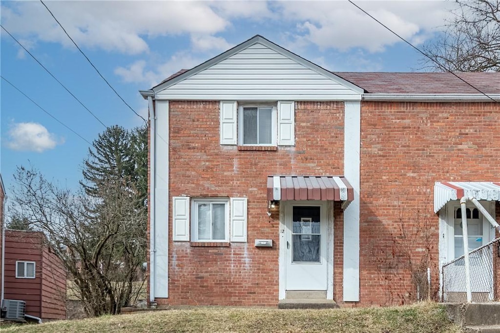 view of front of house with brick siding and cooling unit