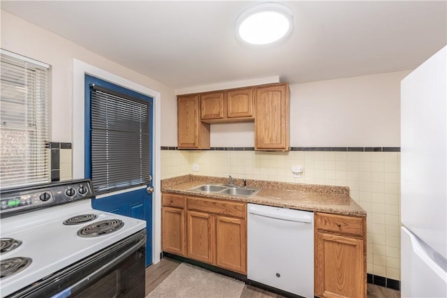 kitchen featuring white dishwasher, a sink, tile walls, electric stove, and brown cabinetry