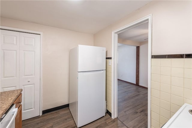 kitchen with white appliances, dark wood-type flooring, wainscoting, and tile walls