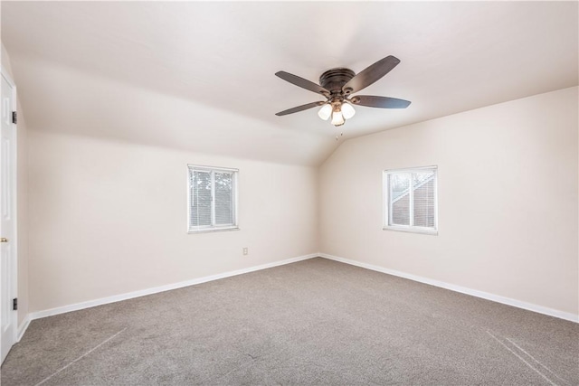 interior space with carpet flooring, vaulted ceiling, and baseboards