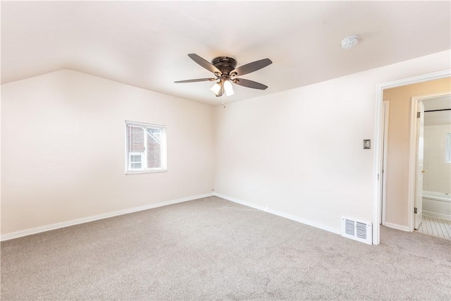 carpeted spare room featuring a ceiling fan, visible vents, and baseboards