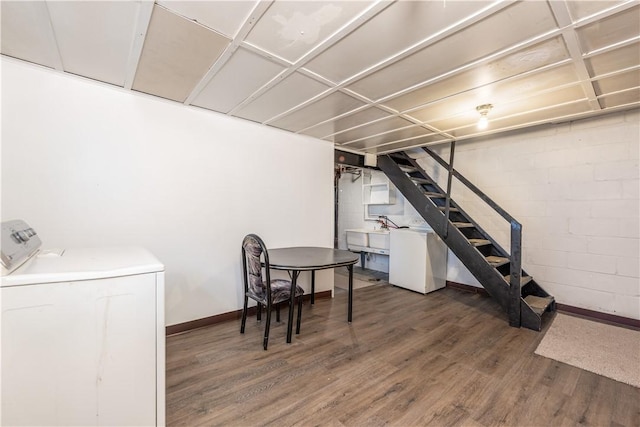 finished below grade area with concrete block wall, stairs, baseboards, and wood finished floors