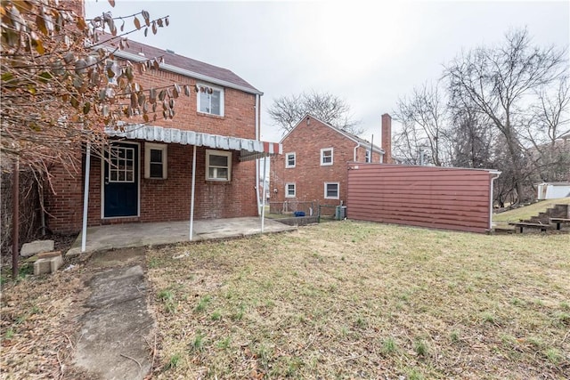 back of house with brick siding, a lawn, a patio area, and fence