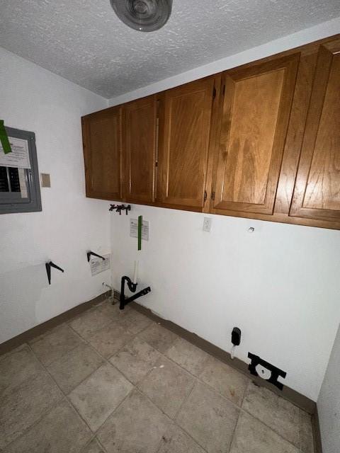 laundry room with a textured ceiling and baseboards