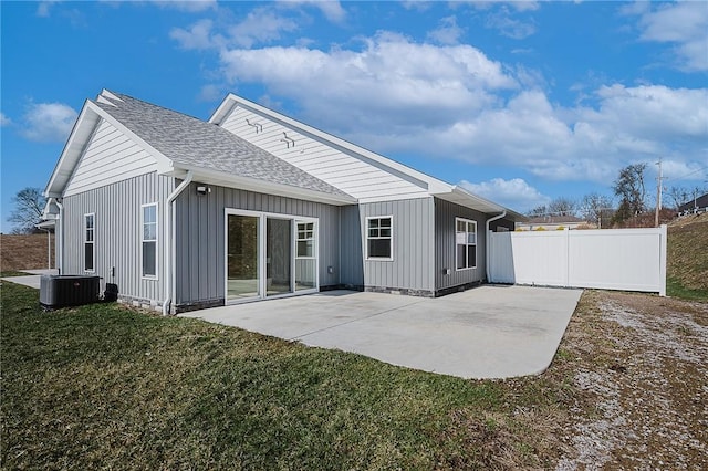 back of house with roof with shingles, fence, a yard, central air condition unit, and a patio area