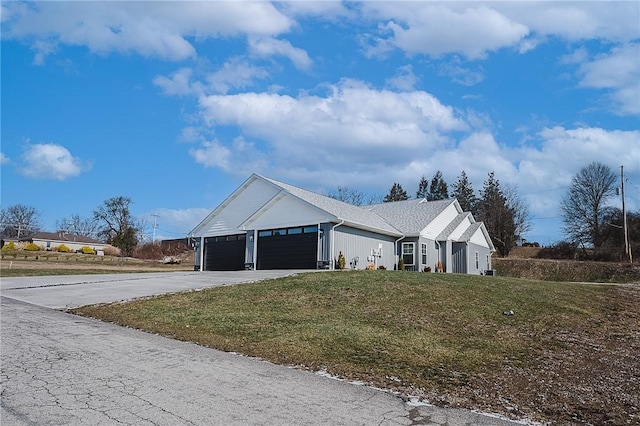 view of front of house featuring a garage, driveway, and a front lawn