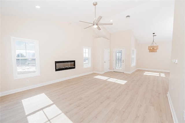 unfurnished living room featuring light wood finished floors, baseboards, and a glass covered fireplace