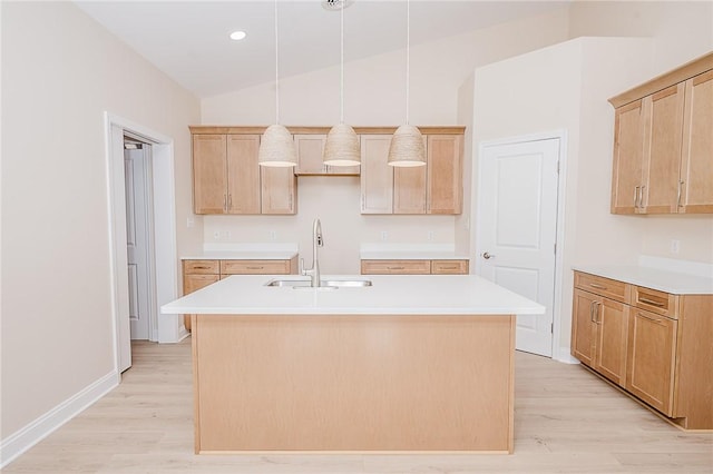 kitchen featuring light wood-style flooring, a center island with sink, vaulted ceiling, and a sink