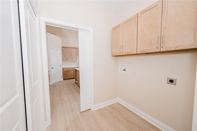 washroom with cabinet space, light wood finished floors, baseboards, hookup for an electric dryer, and washer hookup