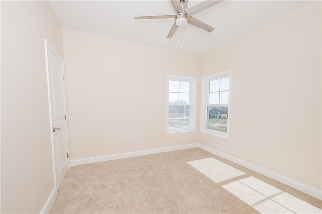 empty room with carpet floors, baseboards, and a ceiling fan