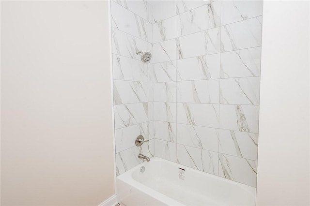 bathroom featuring bathing tub / shower combination and baseboards