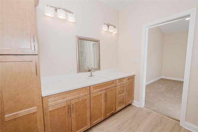 bathroom with wood finished floors, vanity, and baseboards