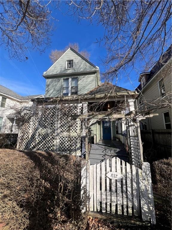 rear view of property with a fenced front yard