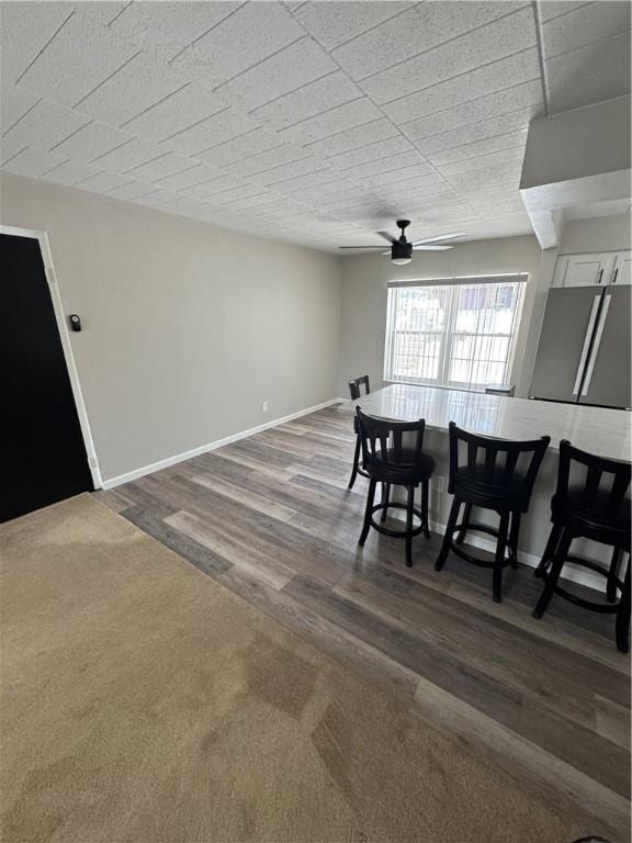 dining area with ceiling fan, baseboards, and wood finished floors