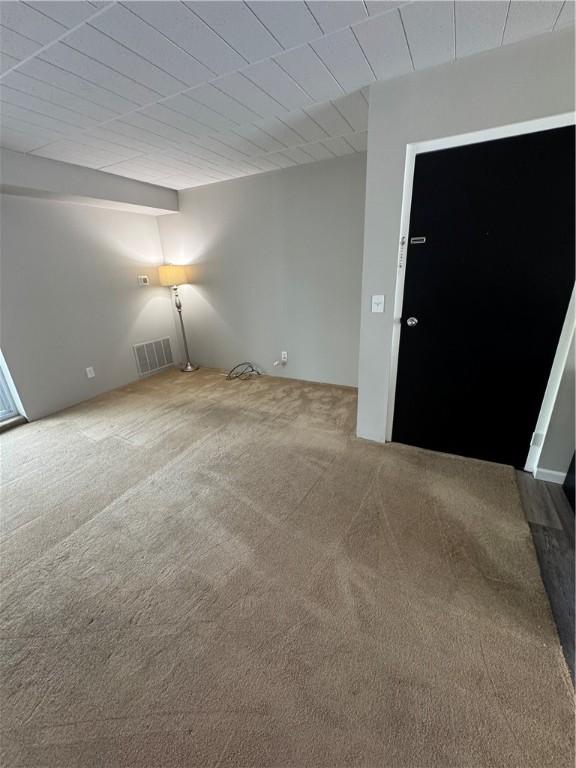 empty room featuring visible vents and carpet flooring