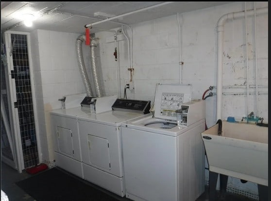 washroom with a sink, laundry area, and washer and dryer