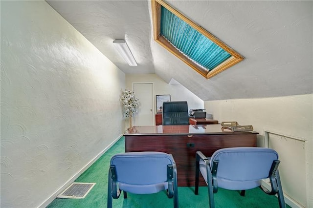 carpeted home office with lofted ceiling, baseboards, visible vents, and a textured wall