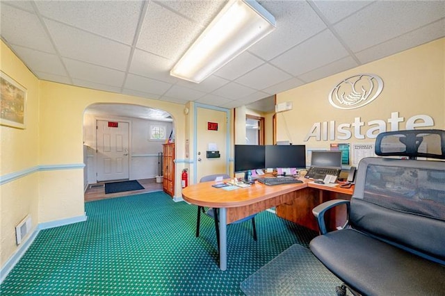 office space featuring arched walkways, visible vents, carpet, and a paneled ceiling
