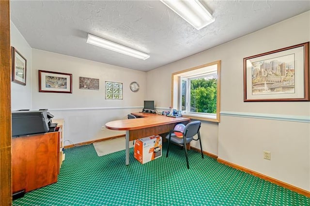 carpeted office space with a textured ceiling and baseboards