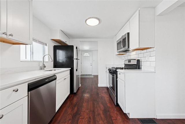 kitchen featuring tasteful backsplash, light countertops, visible vents, appliances with stainless steel finishes, and a sink