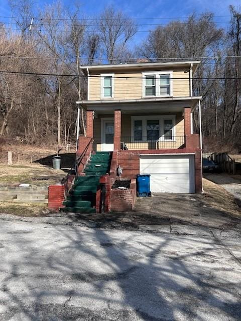 view of front of house with a porch, an attached garage, and aphalt driveway