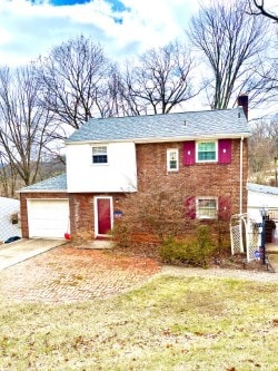 view of front of property with a front yard, concrete driveway, and an attached garage