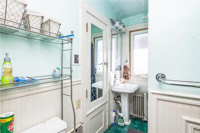 bathroom with wainscoting, radiator heating unit, and tile patterned floors