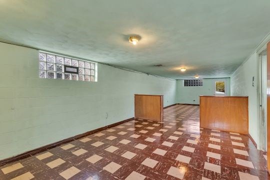 below grade area with baseboards and tile patterned floors