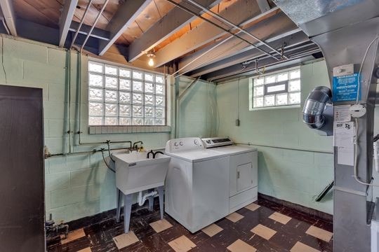 laundry room featuring laundry area, washing machine and dryer, and dark floors