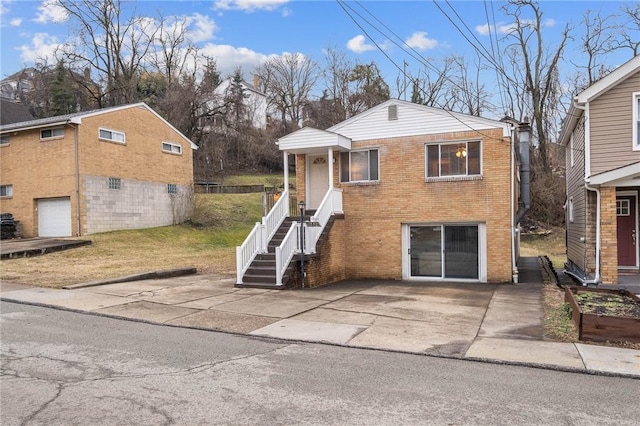 view of front of home featuring driveway, brick siding, and an attached garage