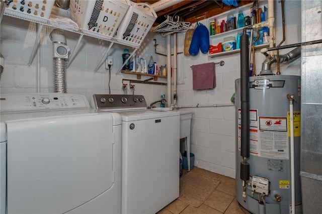 laundry area featuring water heater, laundry area, light tile patterned floors, and washer and clothes dryer