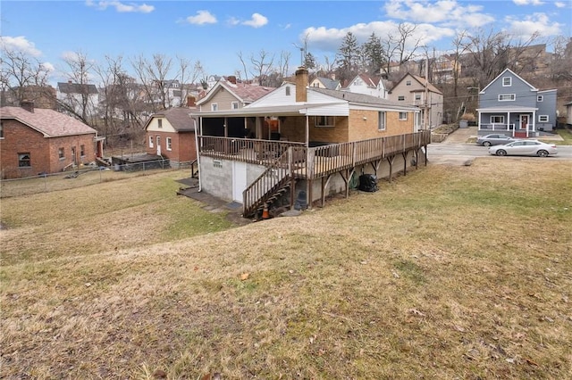 rear view of house with brick siding, a lawn, fence, and a residential view