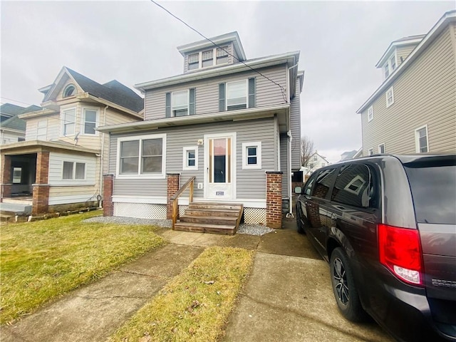 american foursquare style home with a front lawn