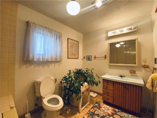 full bath featuring baseboards, toilet, tile patterned flooring, a textured ceiling, and vanity