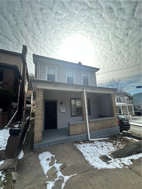 view of front of house with a porch and brick siding