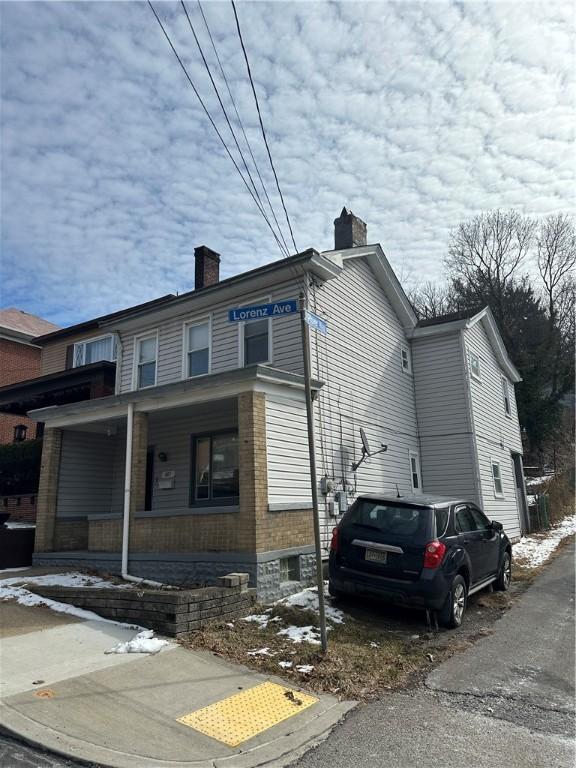 exterior space with a chimney and a porch