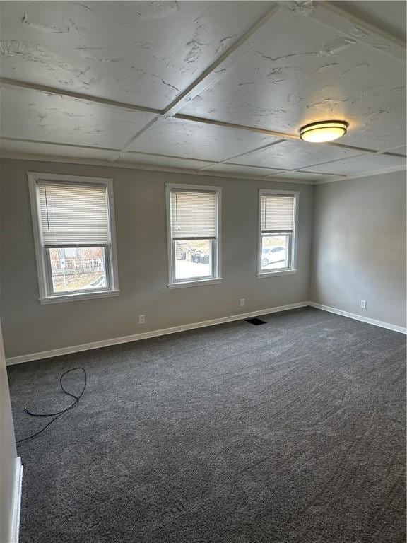 unfurnished room featuring dark carpet, visible vents, and baseboards